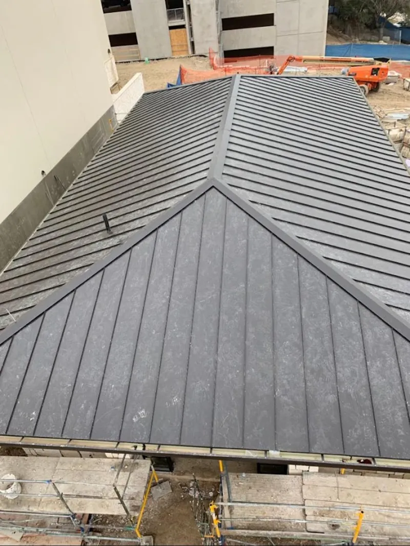 Commercial metal roof construction with crane equipment in Yoakum